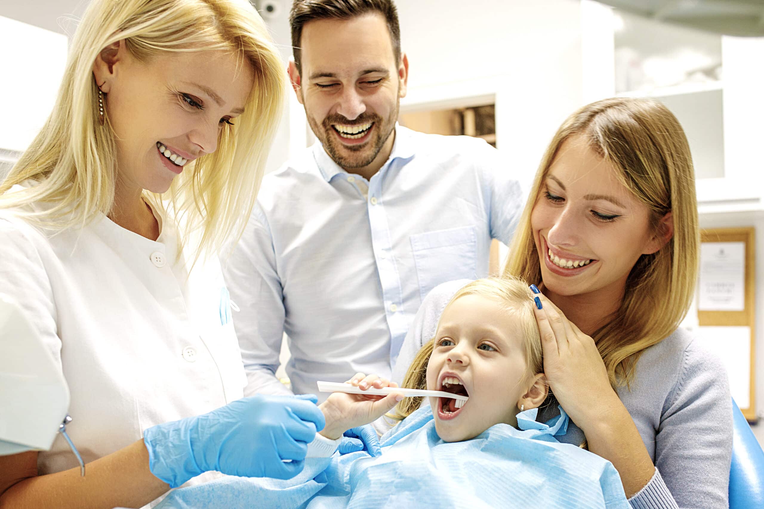 Family dentistry in Dunstable – Dentist treating a cute blonde child in his surgery.